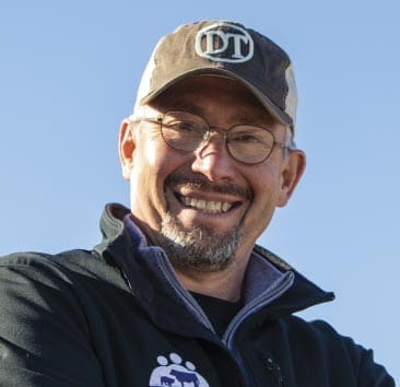 Dr. Dan Thomson smiling and wearing a hat with the doctalk logo 