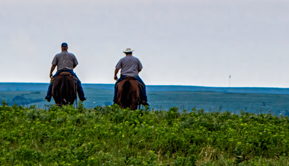 two men riding horses